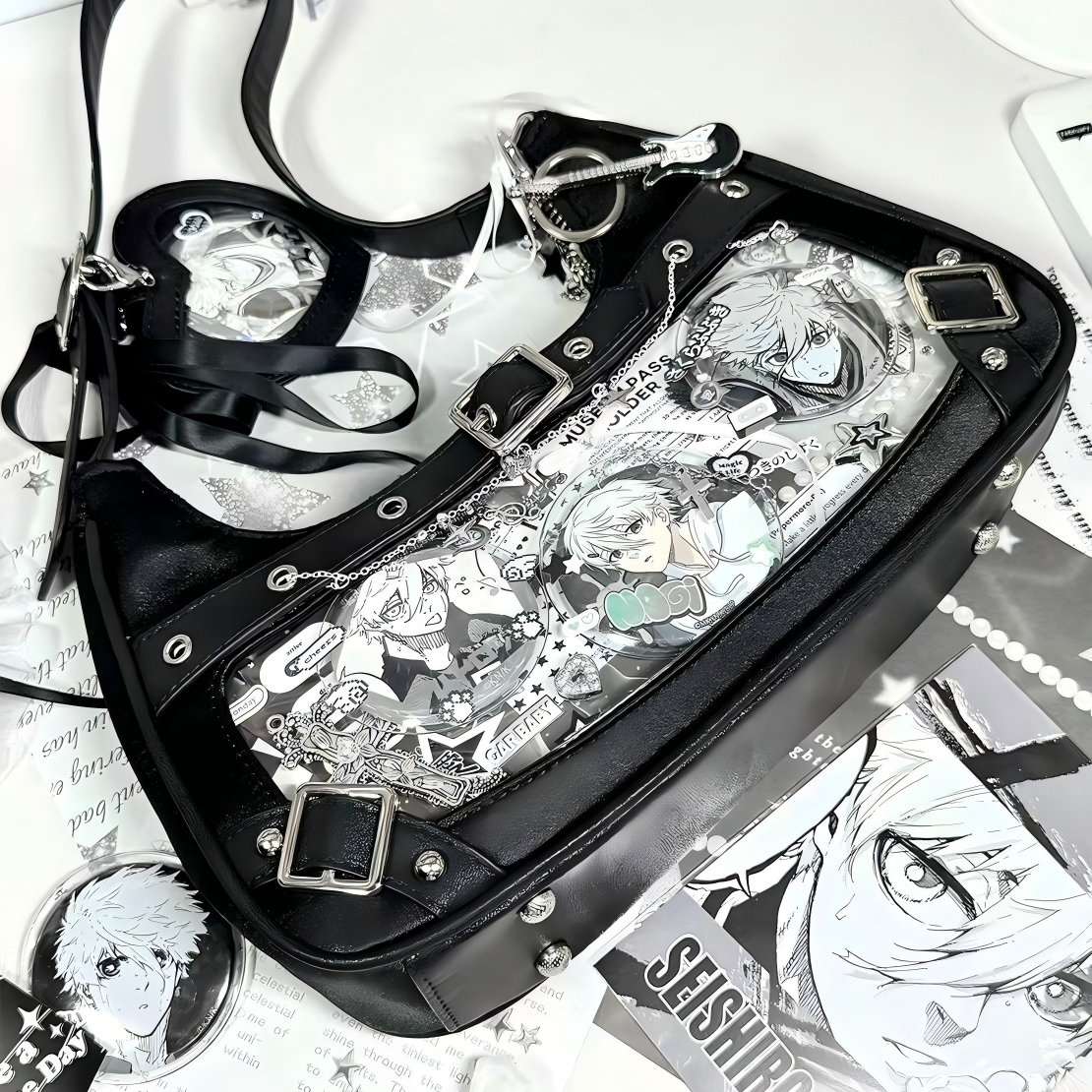 Black buckle-detail ita shoulder bag with clear display window, styled with collectible badges and decorative accessories