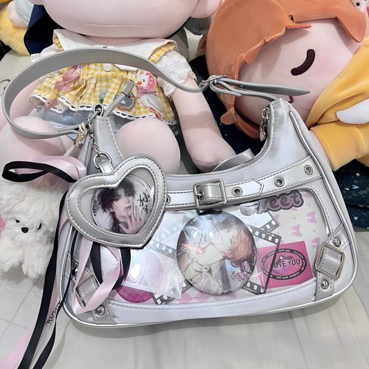 Silver buckle-detail ita shoulder bag with clear display window, shown with character collectibles for styling